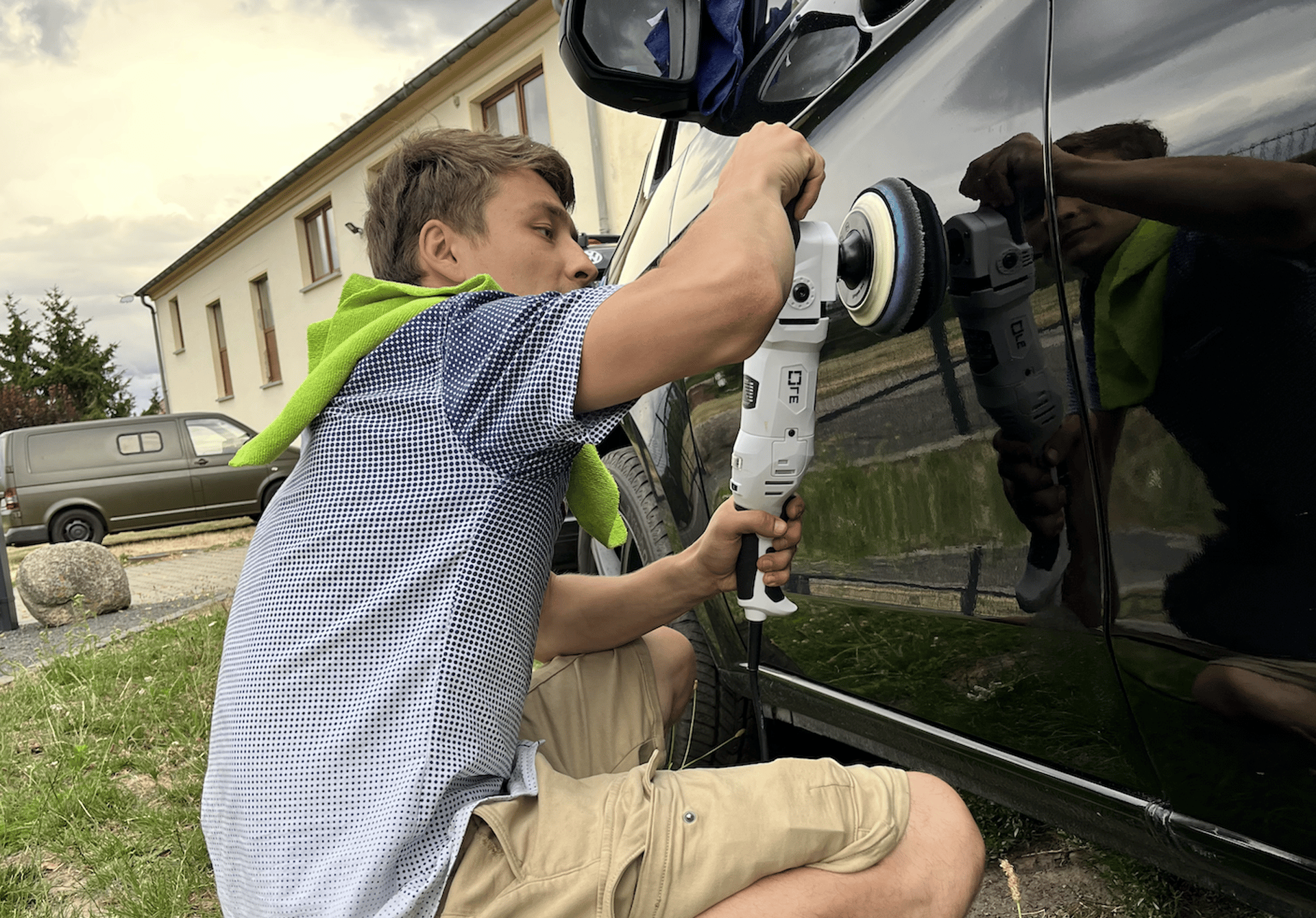 Politurarbeiten am Lack eines Fahrzeugs im Freien